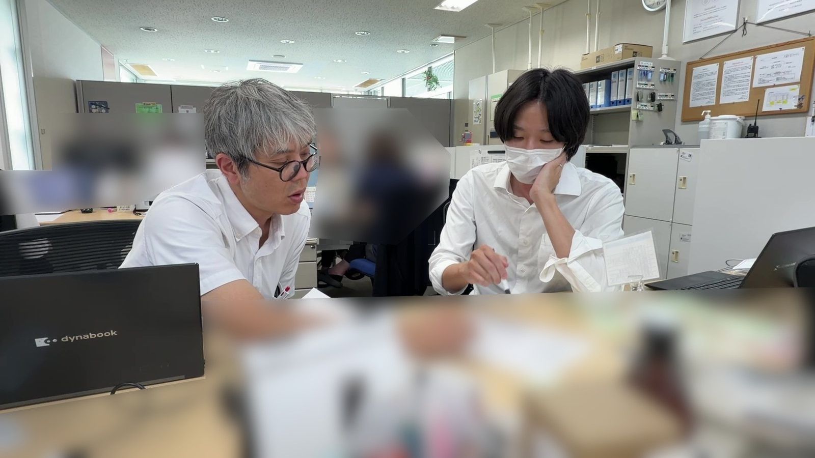 先輩と書類を見ながら打ち合わせる西川さん